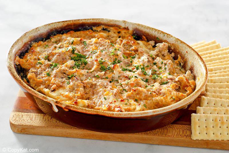 boudin dip in a baking dish with crackers next to it