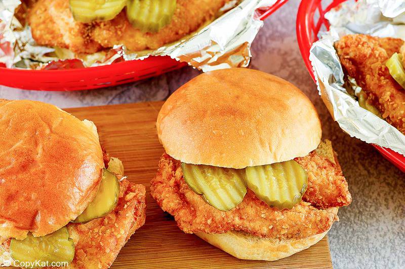 homemade Chick Fil A chicken sandwiches on a board and in baskets