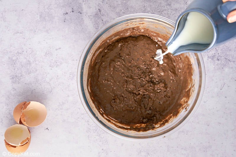 pour milk into a bowl of chocolate pancake batter