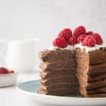 a stack of six chocolate pancakes with a wedge cut out of the stack