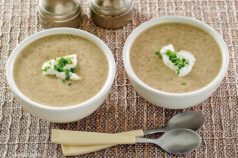 two bowls of homemade gluten-free cream of mushroom soup and two spoons