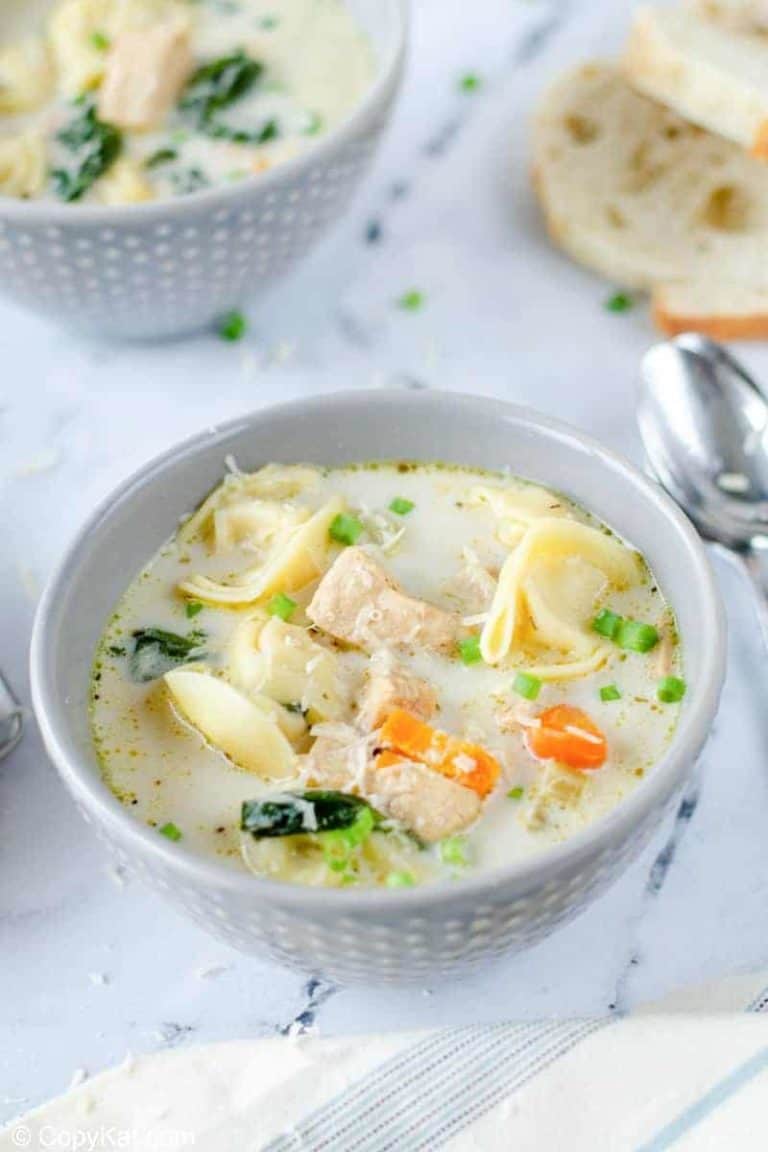 two bowls of creamy chicken tortellini soup and bread slices