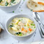 two bowls of Instant Pot chicken tortellini soup and bread slices