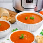 three bowls of homemade tomato soup in front of an Instant Pot