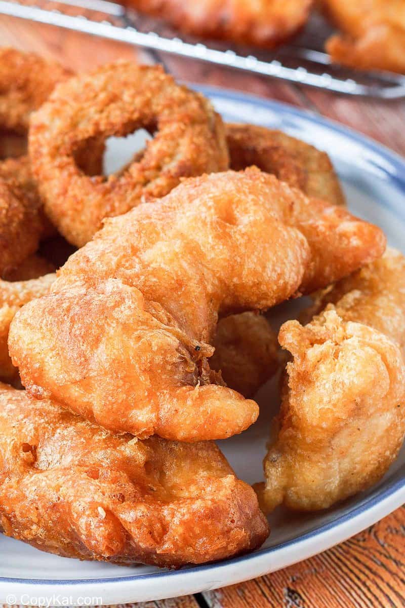 closeup of homemade Long John Silver's Chicken Planks and onion rings on a plate