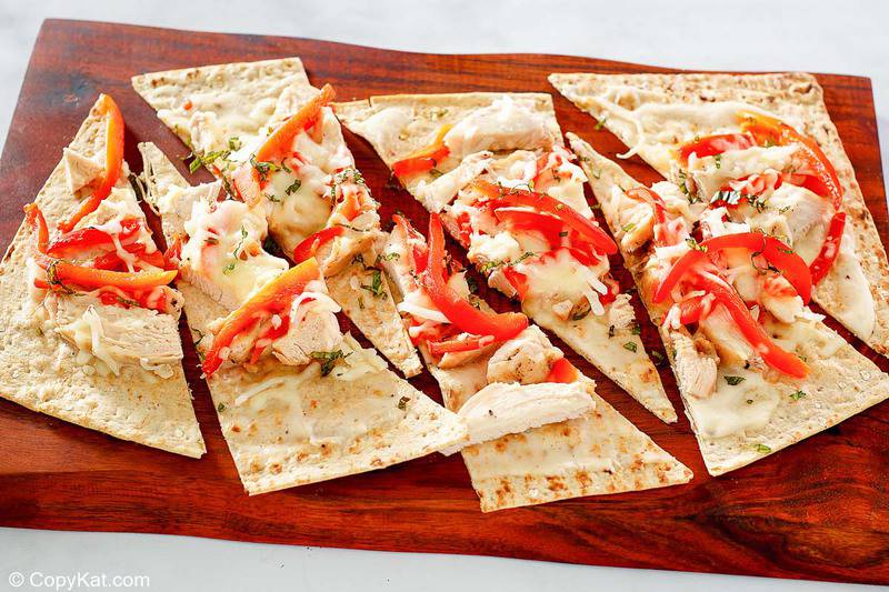 slices of homemade Olive Garden grilled chicken flatbread on a wood board