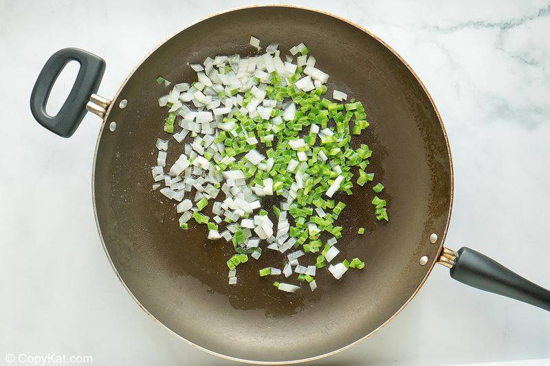 chopped onions and green bell peppers in a skillet