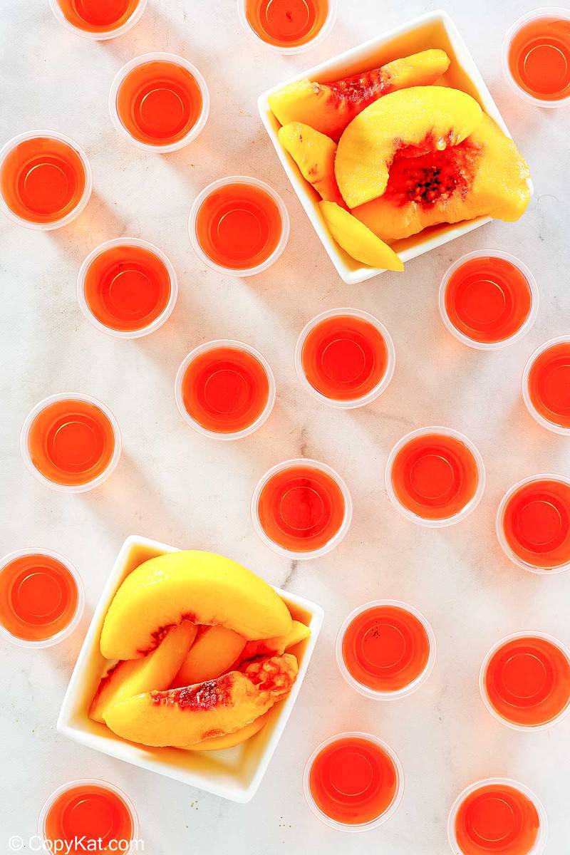 overhead view of peach jello shots and peach slices