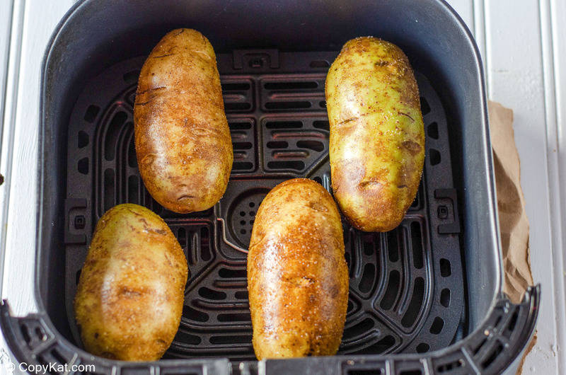 four russet potatoes in an air fryer basket