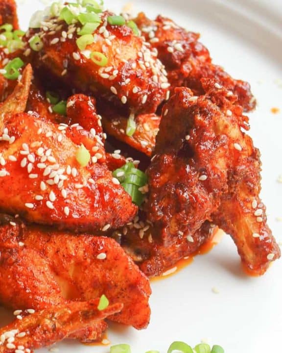 spicy chicken wings with sauce and sesame seeds on a plate