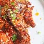 spicy chicken wings topped with sesame seeds on a plate