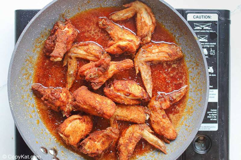 fried chicken wings and spicy sauce in a skillet
