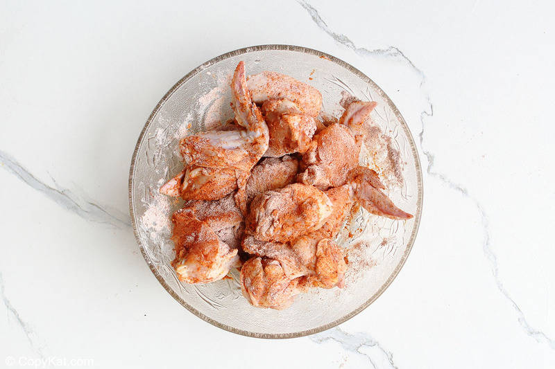 raw chicken wings and spicy seasoning in a bowl