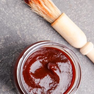 a jar of homemade bourbon barbecue sauce and a basting brush