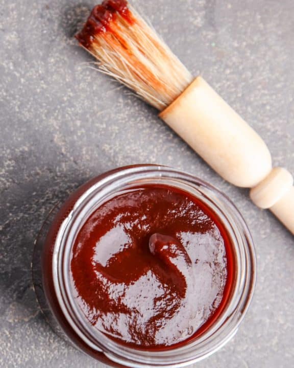 a jar of homemade bourbon barbecue sauce and a basting brush