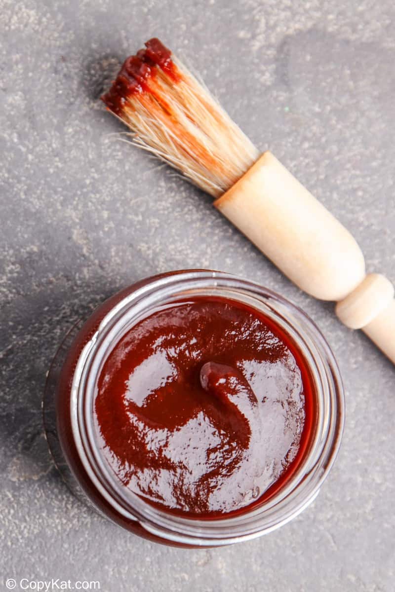 a jar of homemade bourbon barbecue sauce and a basting brush
