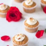 carrot cake cupcakes and a rose on a table