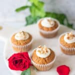 four carrot cake cupcakes with cream cheese frosting