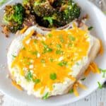 cheesy sour cream baked pork chop and cooked broccoli on a plate