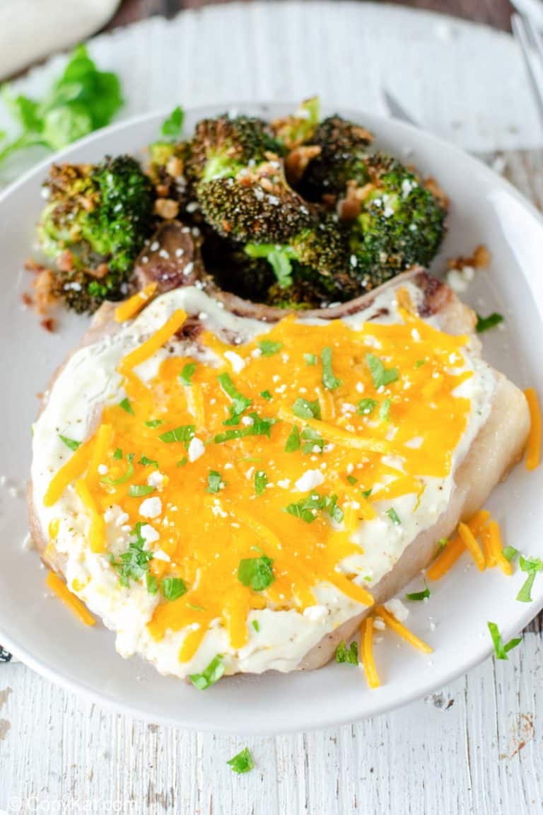 cheesy sour cream baked pork chop and roasted broccoli on a plate