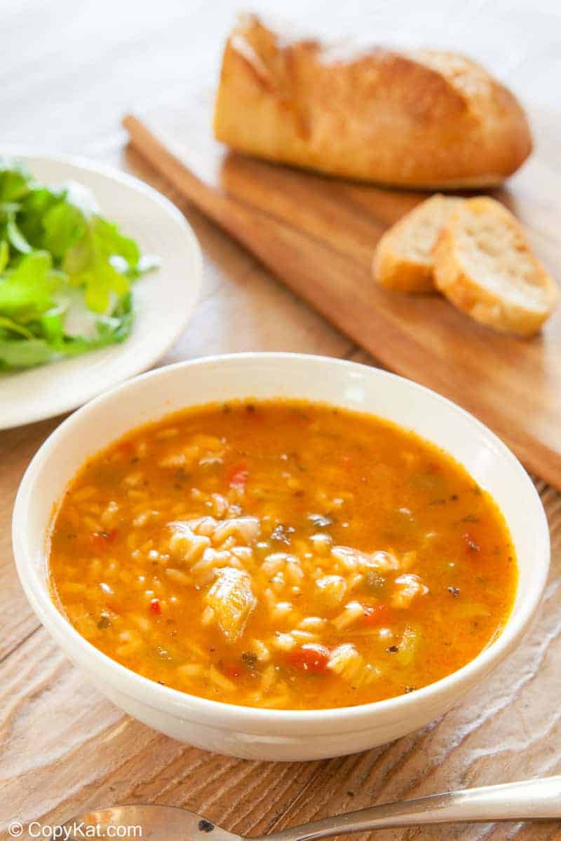 a bowl of chicken gumbo soup and bread on a cutting board