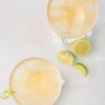 overhead view of two homemade Chili's Presidente Margaritas and limes