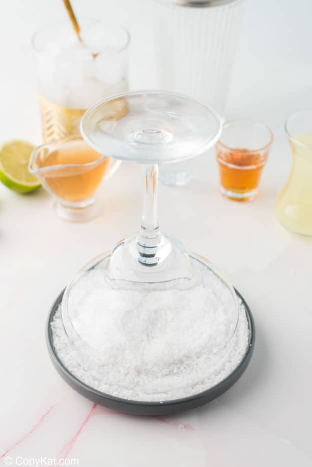 rimming a margarita glass with salt
