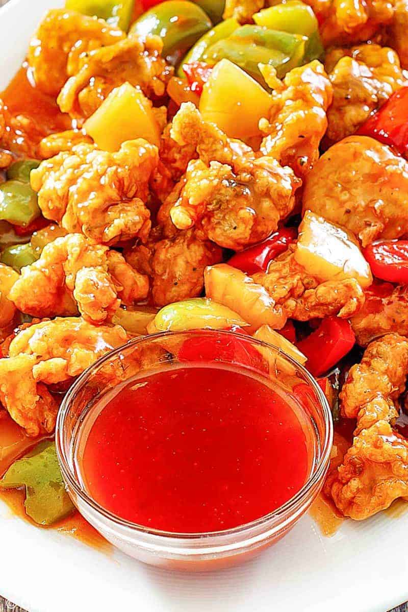 sweet and sour chicken and a bowl of homemade sweet and sour sauce