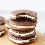 four chocolate sandwich cookies stacked with a bite out of the top one