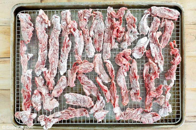 cornstarch coated beef strips on a rack