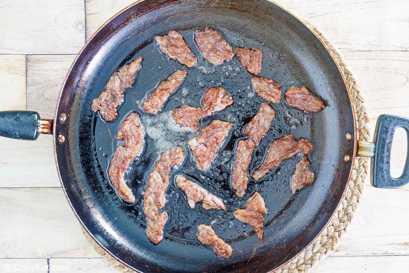 frying beef strips in a skillet