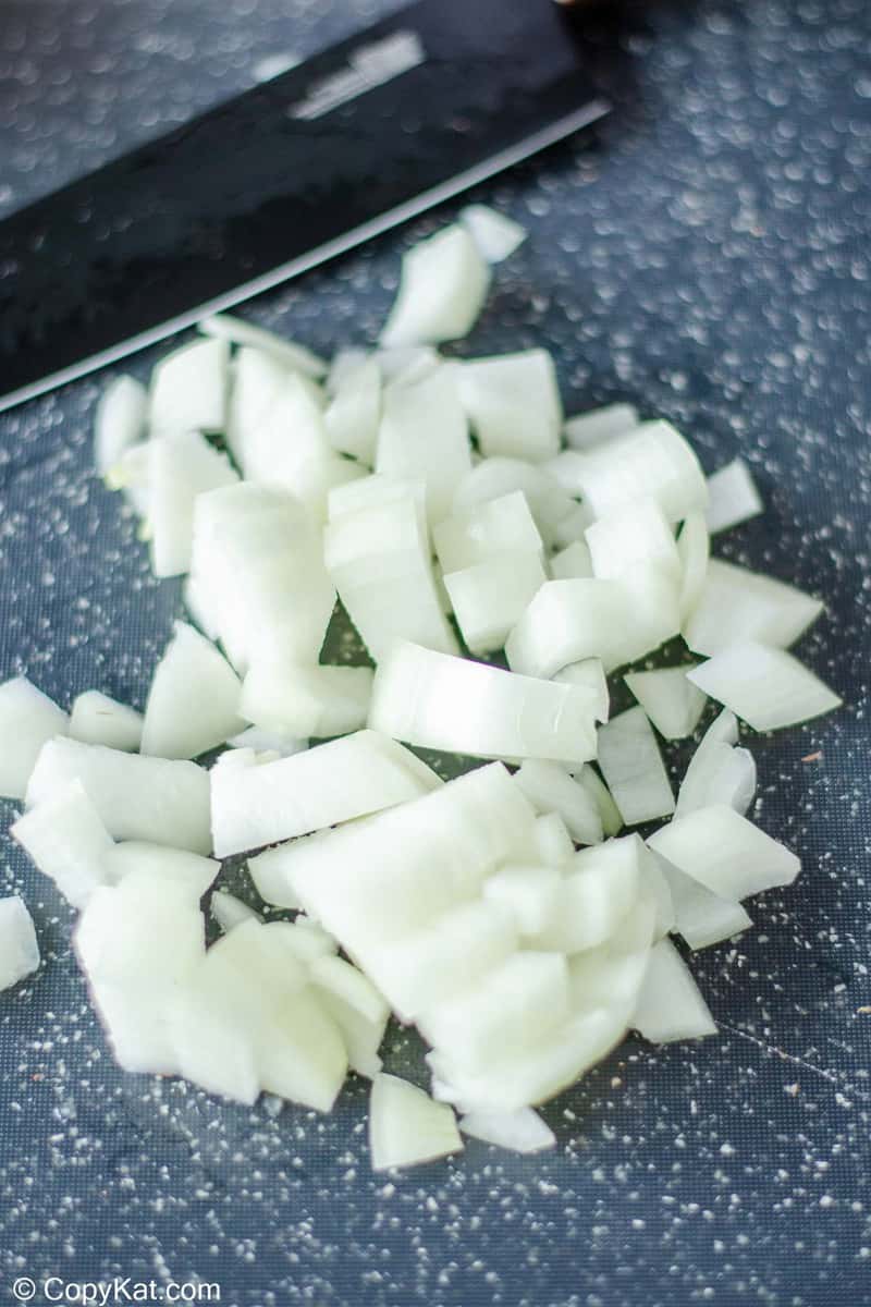 chopped onions and a knife on a cutting board