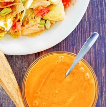 overhead view of homemade French salad dressing in a bowl and on a salad