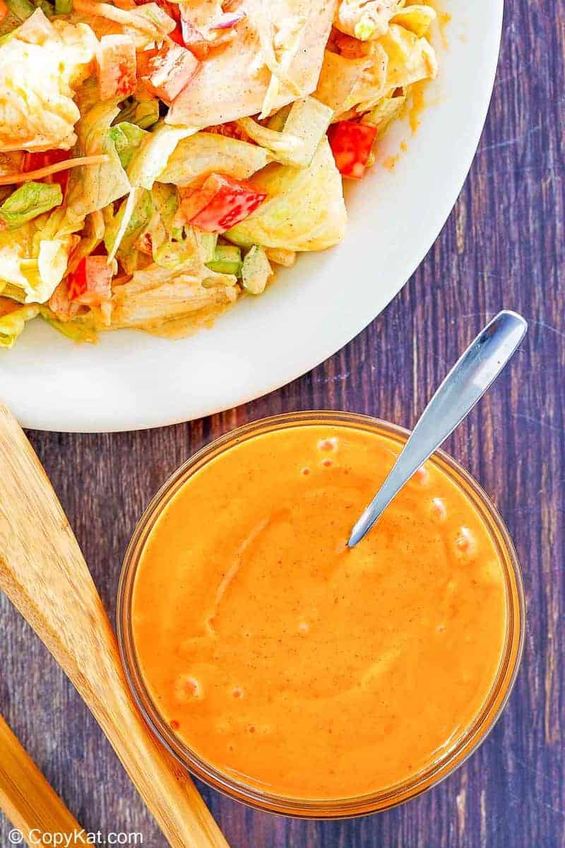 overhead view of homemade French salad dressing in a bowl and on a salad