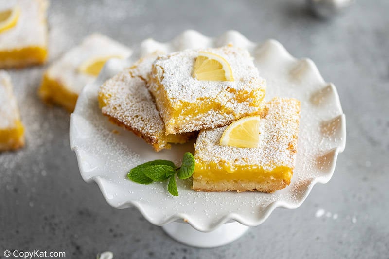 lemon bars on a small cake stand