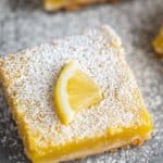 lemon bar with powdered sugar and lemon slice on top