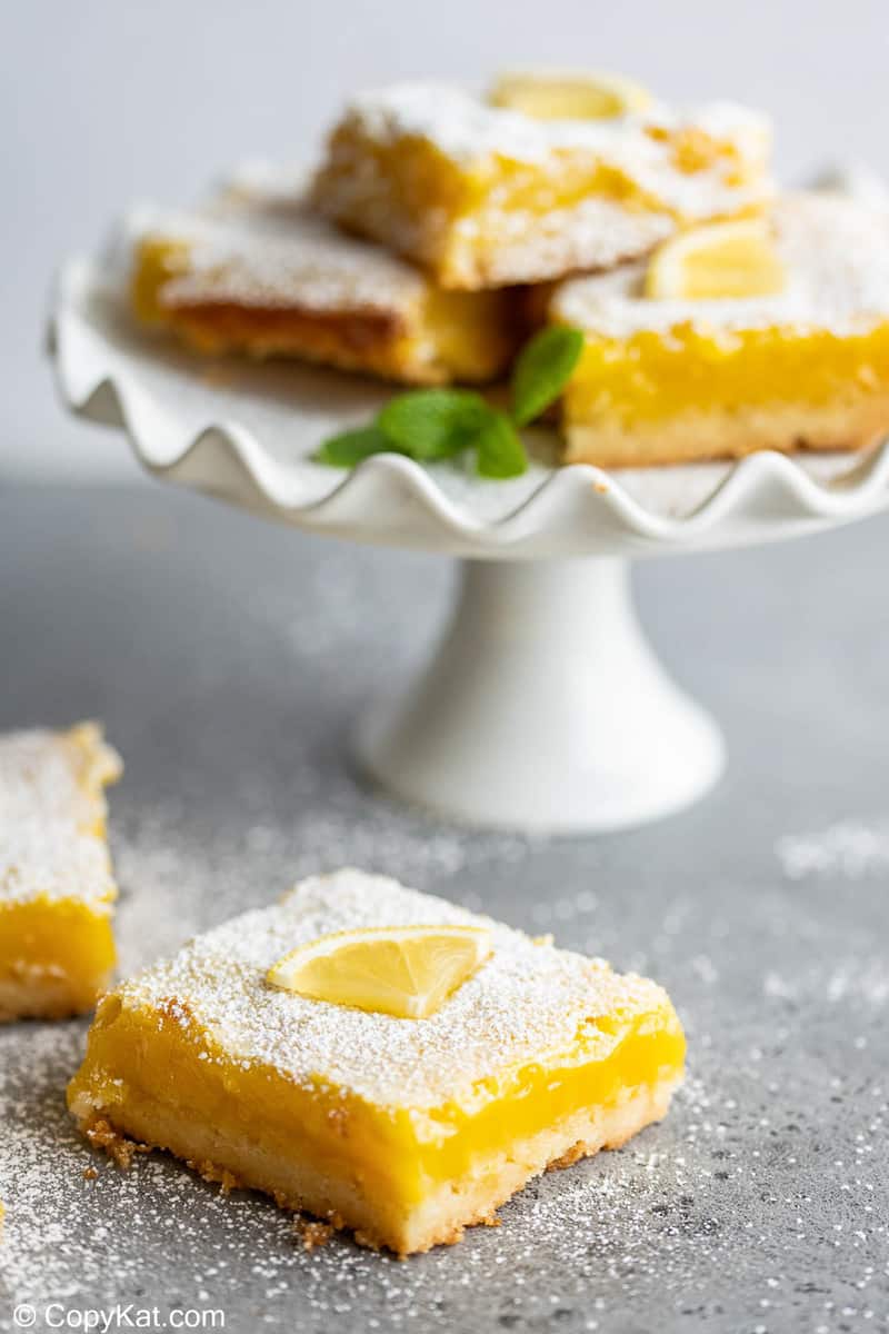 lemon bars on a table and small cake stand