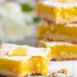 four lemon bars with a bite out of one of them