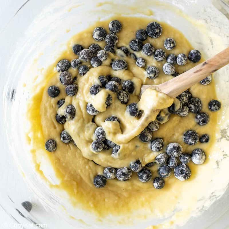 folding blueberries into muffin batter