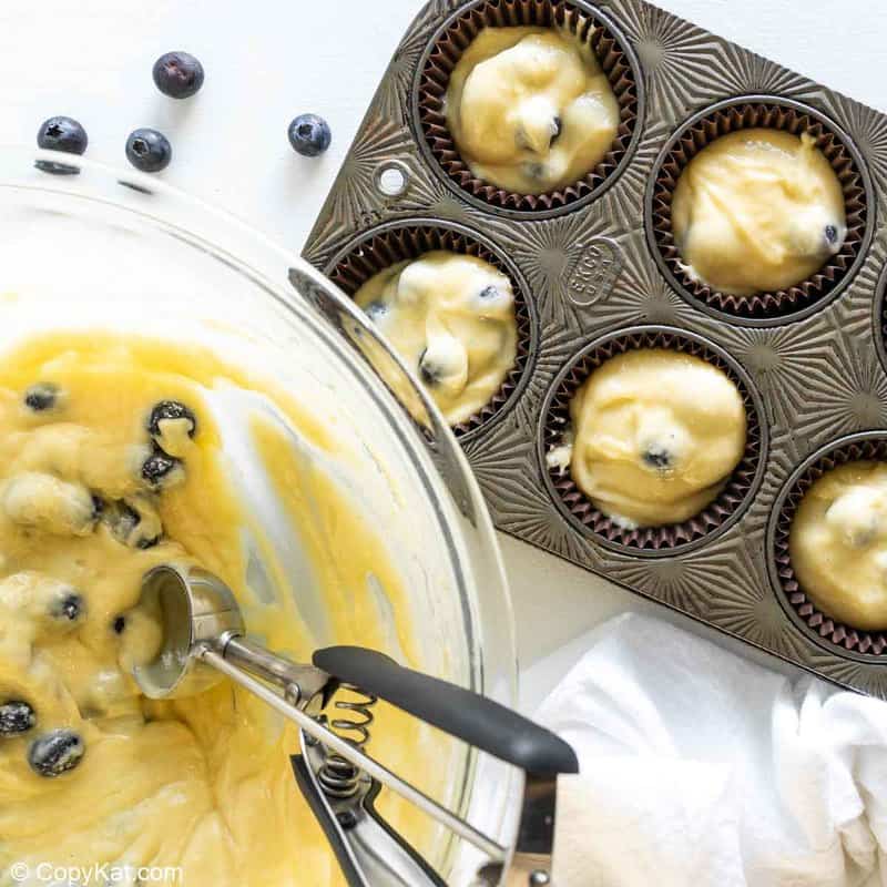 blueberry muffin batter in a bowl and a muffin tin