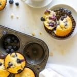 overhead view of blueberry muffins in a muffin tin and on a plate