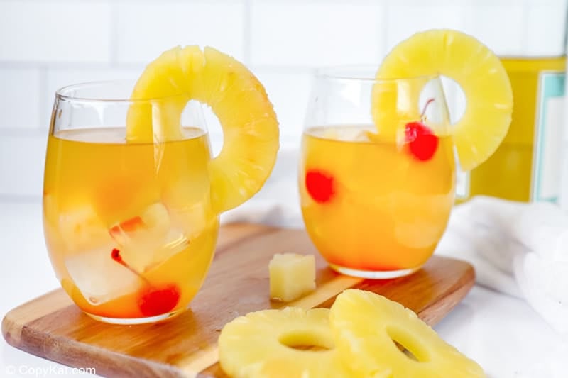 two glasses of pineapple white wine sangria garnished with pineapple ring