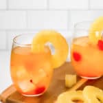 two glasses of pineapple white wine sangria and fresh pineapple