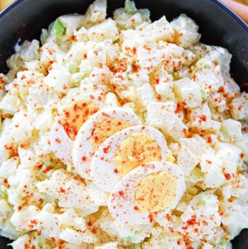 potato salad topped with sliced egg and paprika