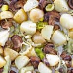 overhead view of roasted leeks, potatoes, and mushrooms on a sheet pan
