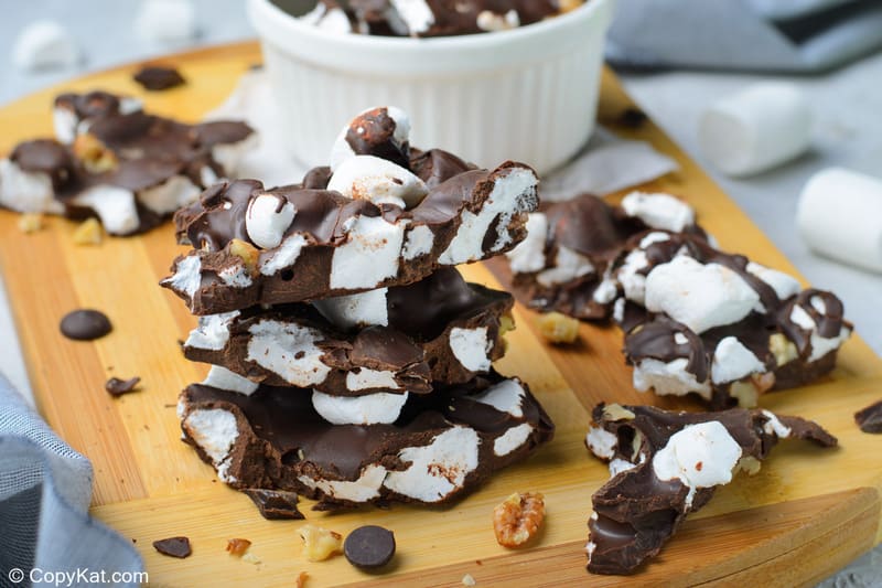 rocky road candy with walnuts stacked on a wood board and in a bowl