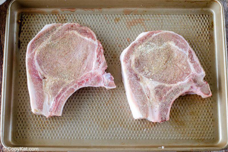 seasoned pork chops on a baking sheet