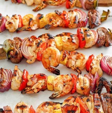 six shish kabobs with chicken, steak, shrimp, and vegetables