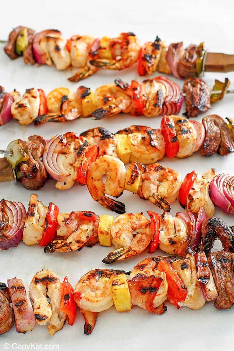 six shish kabobs with chicken, steak, shrimp, and vegetables