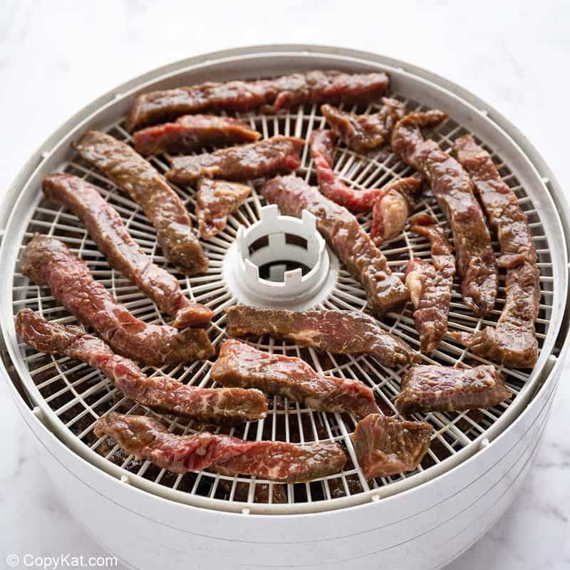 spicy marinated beef strips in a food dehydrator